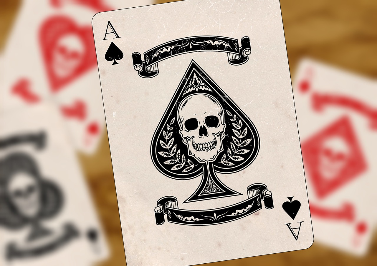 An Ace of Spades featuring a skull design, with similar Aces of other suits in the background